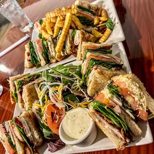 Turkey Bacon Club Sandwich with fries and a salad