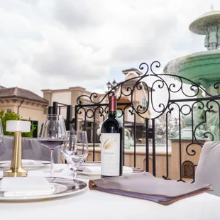 a table setting with a fountain in the background