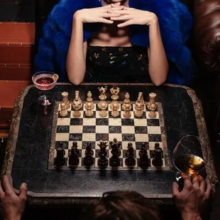 a woman sitting at a table with a chess board
