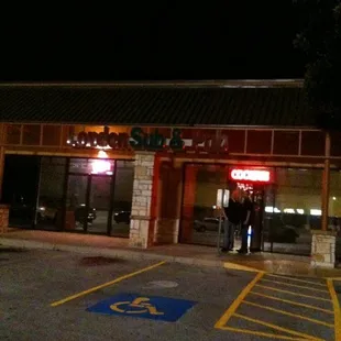 a man standing in front of a restaurant at night