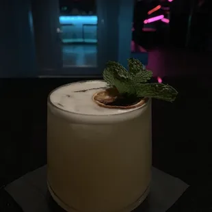a white cake with a mint leaf on top