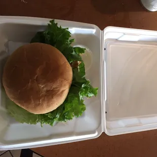 a hamburger in a styrofoam container