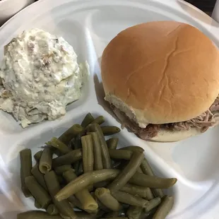 a hamburger, green beans, and coleslaw