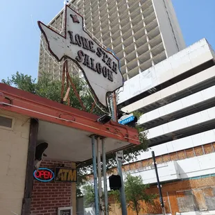 a lone star sign in front of a tall building