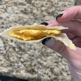 a hand holding a half eaten taco