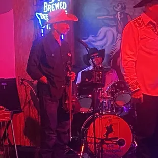 a band performing in front of a neon sign