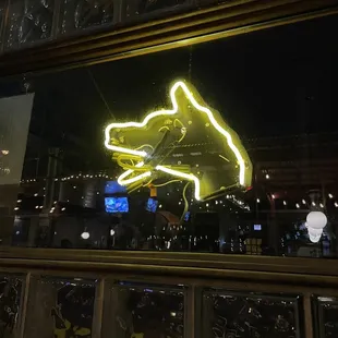 a neon sign in the window of a bar