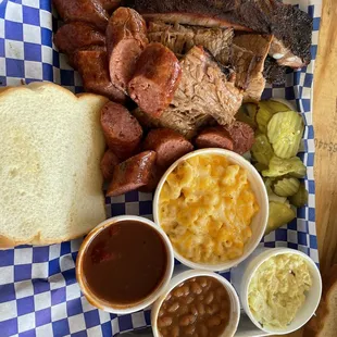 Three meat plate with brisket, ribs, and sausage.