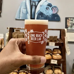 a hand holding a glass of beer