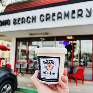 a hand holding a cup of ice cream
