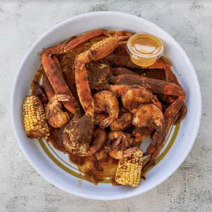 a bowl of crab legs and corn on the cob