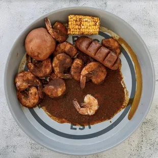 a plate of food with corn on the cob