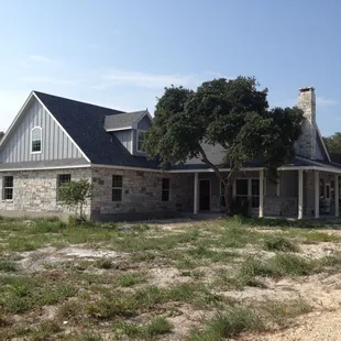 the front of a house with a tree in the yard