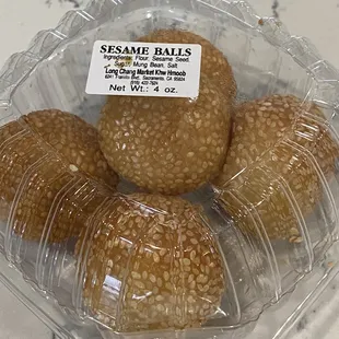 three sesame balls in a plastic container