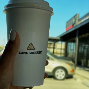 a hand holding a cup of coffee