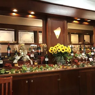 a bar with sunflowers and bottles of wine