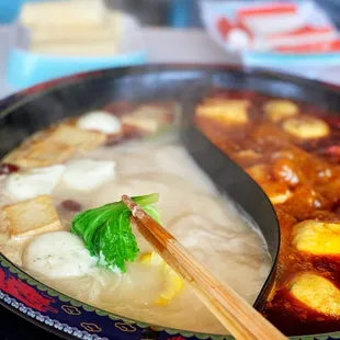 a bowl of soup with chopsticks