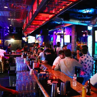a crowded bar with people sitting at the bar