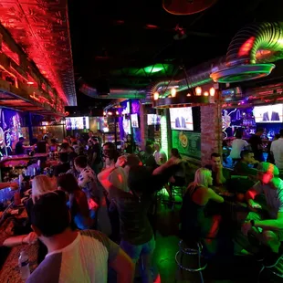 a crowded bar with neon lights