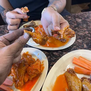 two plates of wings and carrots