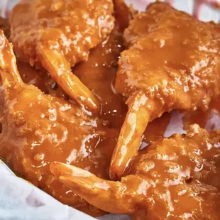 a basket of chicken wings with sauce