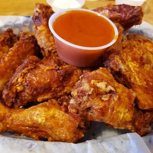 a plate of chicken wings and a bowl of sauce