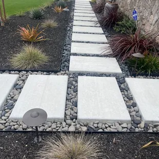 a stone walkway in front of a house