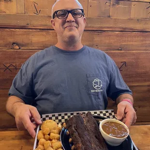 Husband with his Outpost platter (tots, beans, Ribs and a corn muffin) yum
