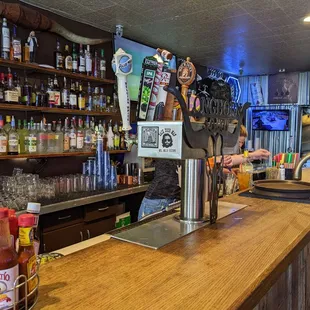 a bar with a counter and shelves full of bottles