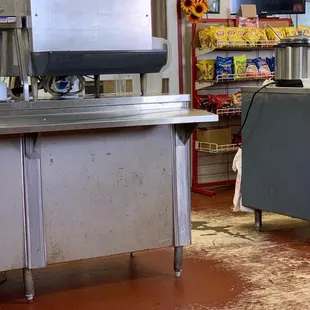 a commercial kitchen with a counter and chairs