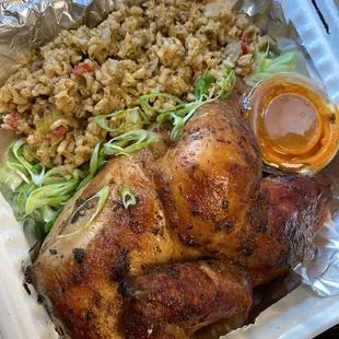 Their local, half rotisserie chicken, made to go, on a bed of their home made dirty rice, with their North African harissa sauce.