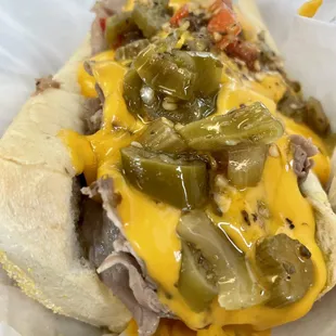 a hot dog with cheese and peppers