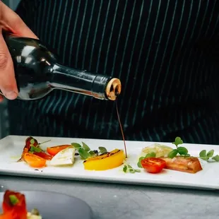 a chef drizzling sauce on a dish
