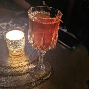 a glass of alcohol and a candle