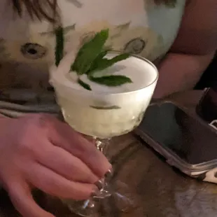 a woman holding a glass of alcohol
