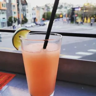 a drink in a glass with a straw and a lime slice
