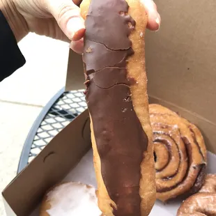 a hand holding a donut in a box