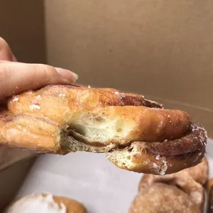 a hand holding a half eaten doughnut
