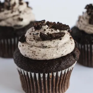 three chocolate cupcakes with oreo frosting