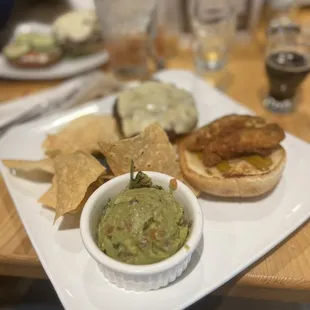 a plate of food with chips and guacamole