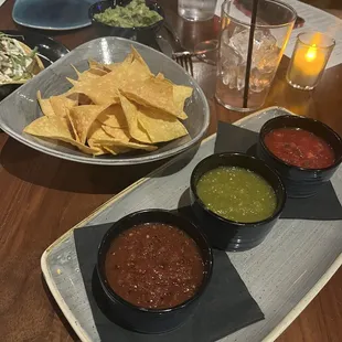 a plate of chips, salsa, and salsa dips
