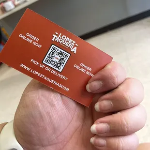 a hand holding a business card