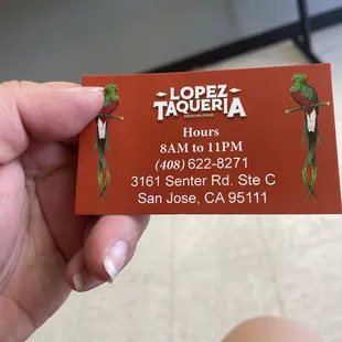 a hand holding a business card