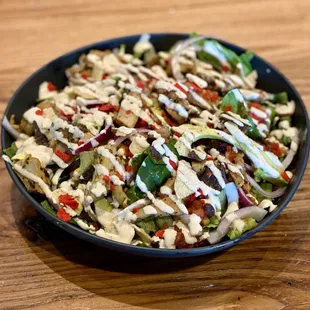 a bowl of salad on a wooden table