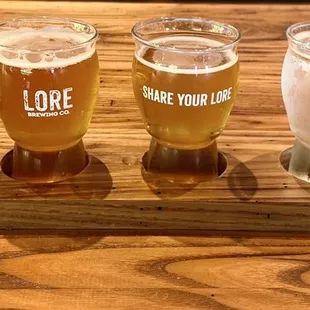 four glasses of beer on a wooden tray