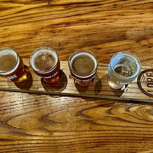 a flight of beers on a wooden table