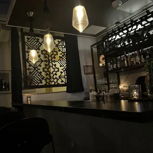 a bar with chairs and a bar counter