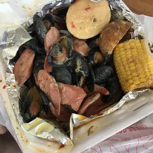 Mussels, shrimp, sausage, potatoes and corn in a delicious sauce