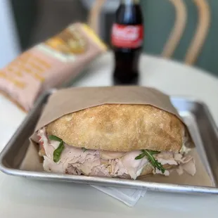 TACCHINO -- Turkey, avocado aioli, stracciatella cheese, roasted almonds, heirlooms tomatoes, arugula, crispy onions.