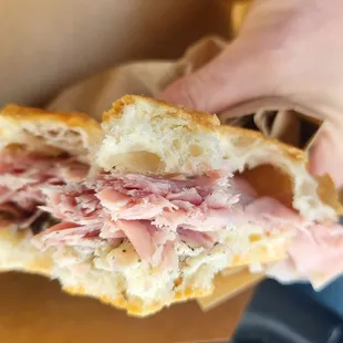 a person holding a half eaten sandwich